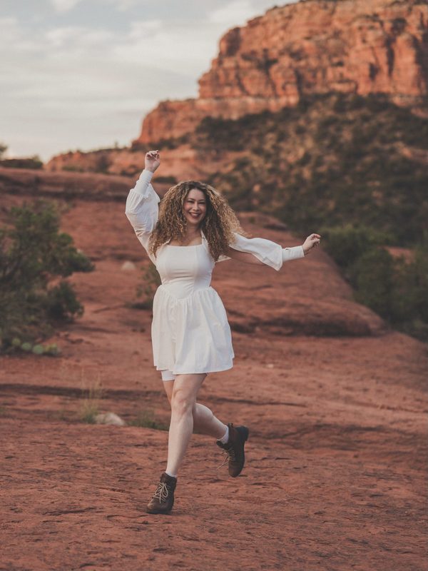 LeAura dancing on a red rock trail in Sedona